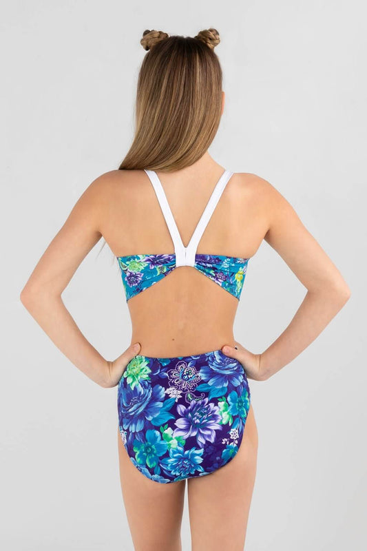 Girl from the back in a stylish floral gymnastics leotard with a V-shape back and multi-colored patterns.