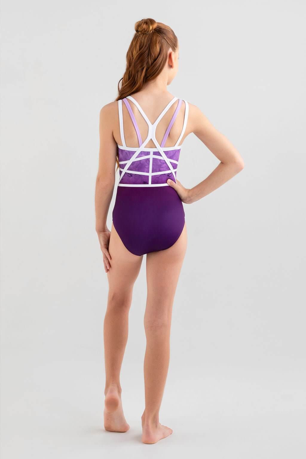 Girl wearing the Misha Leotard in purple, showcasing the stylish triple straps and unique ombre design.