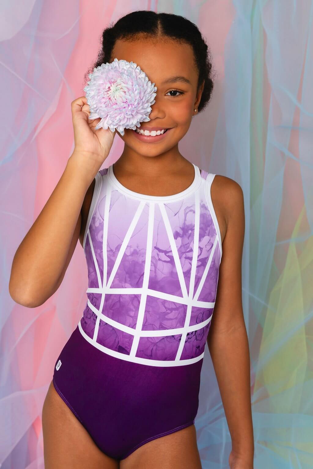 Girl in Misha Leotard, showcasing dusky purple ombre and floral detail, inspired by Paris romance.
